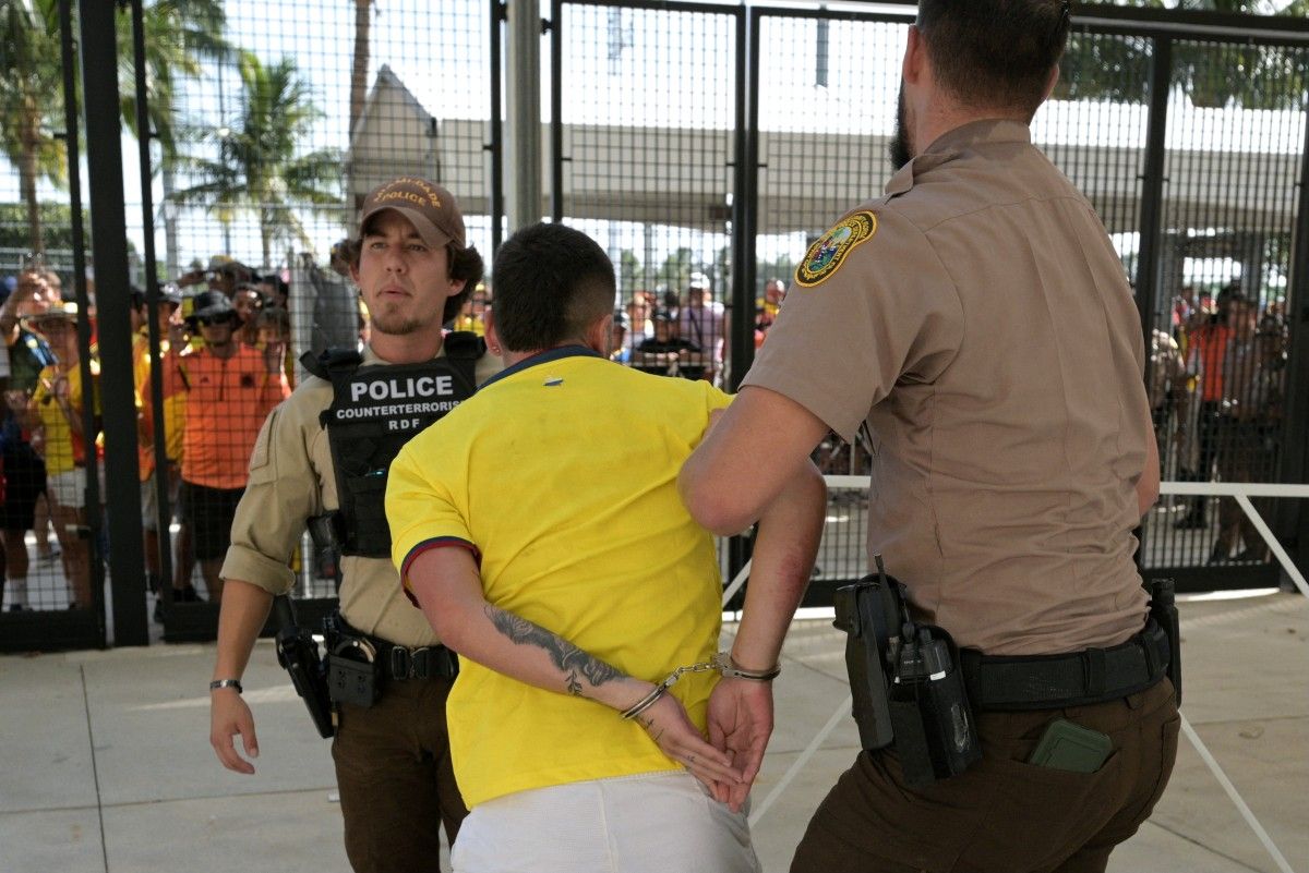 Un hincha colombiano yéndose detenido del estadio.