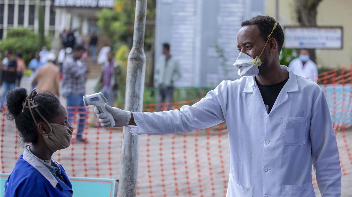 Personal del hospital Zewditu Memorial de Adís Abeba toma la temperatura a una mujer que se dispone a entrar en el centro sanitario.