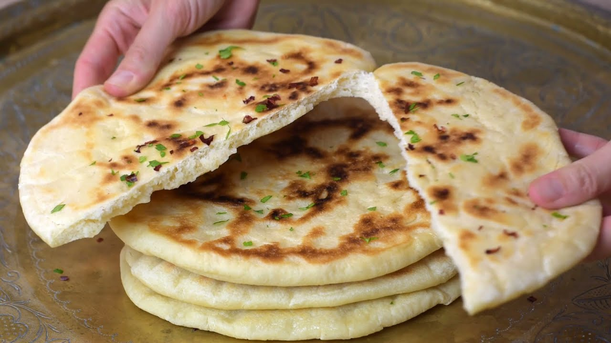 El Naan es un pan plano, elaborado de harina de trigo y generalmente con levadura. 