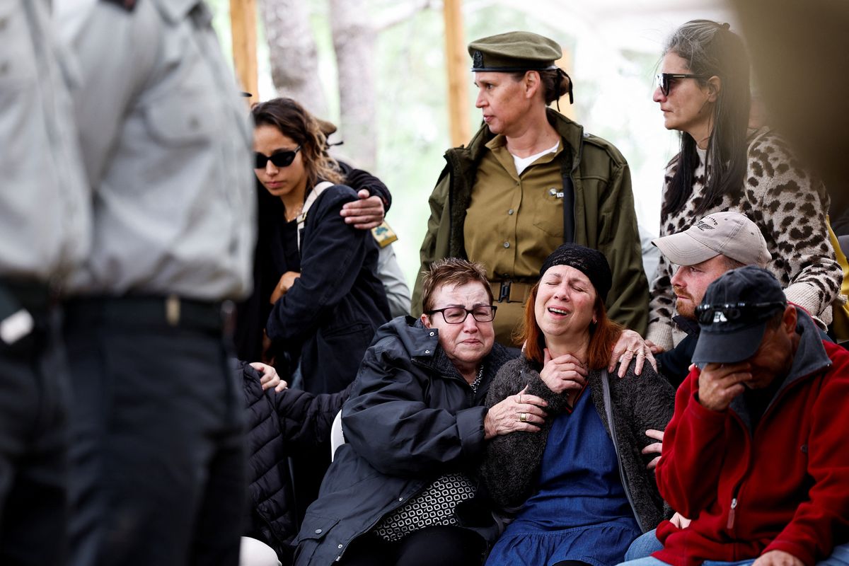 Varias personas reaccionan durante el funeral del capitán Liron Snir, de 25 años, un soldado israelí que murió en el norte de la Franja de Gaza en medio de la operación terrestre en curso del ejército israelí contra el grupo islamista palestino Hamás, en el cementerio militar de Monte Herzl en Jerusalén, 22 de noviembre de 2023. 
