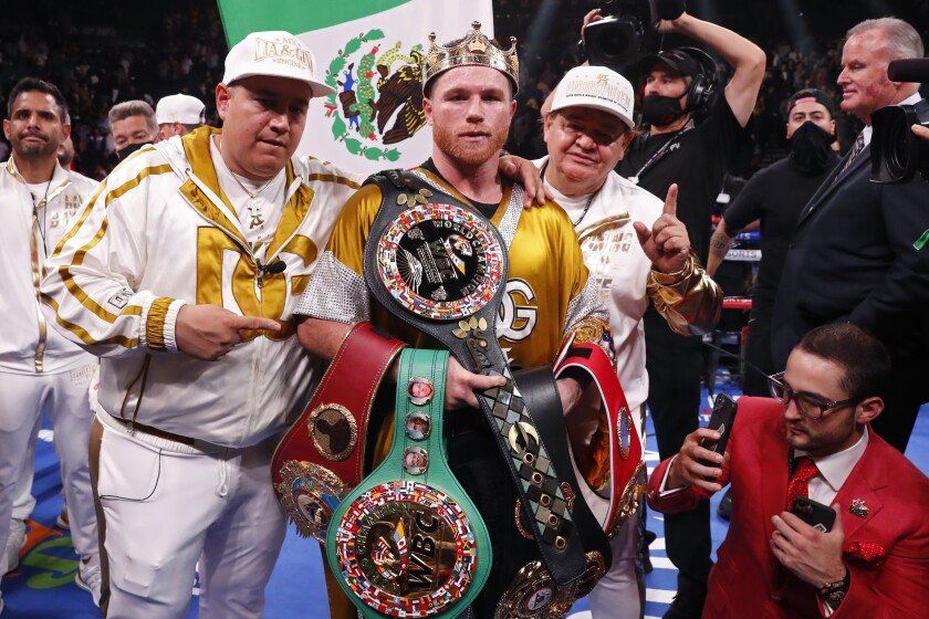 Canelo, el nuevo rey unificado supermediano, posa con su entrenador, Edison Omar (Eddy) Reinoso (a su derecha), tras noquear a Plant en el MGM Grand Garden Arena de Las Vegas. El DT cumplió 45 años el mismo día que su pupilo hizo historia para el boxeo latinoamericano.