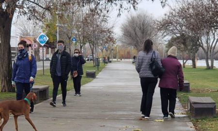 Ciudadanos neuquinos caminan por una plaza con barbijos. Ciudadanos neuquinos caminan por una plaza con barbijos.