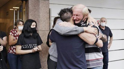 Pedro, el padre de Roberto Sabo, asesinado en Ramos Mejía, se abraza con sus nietos en el velatorio.