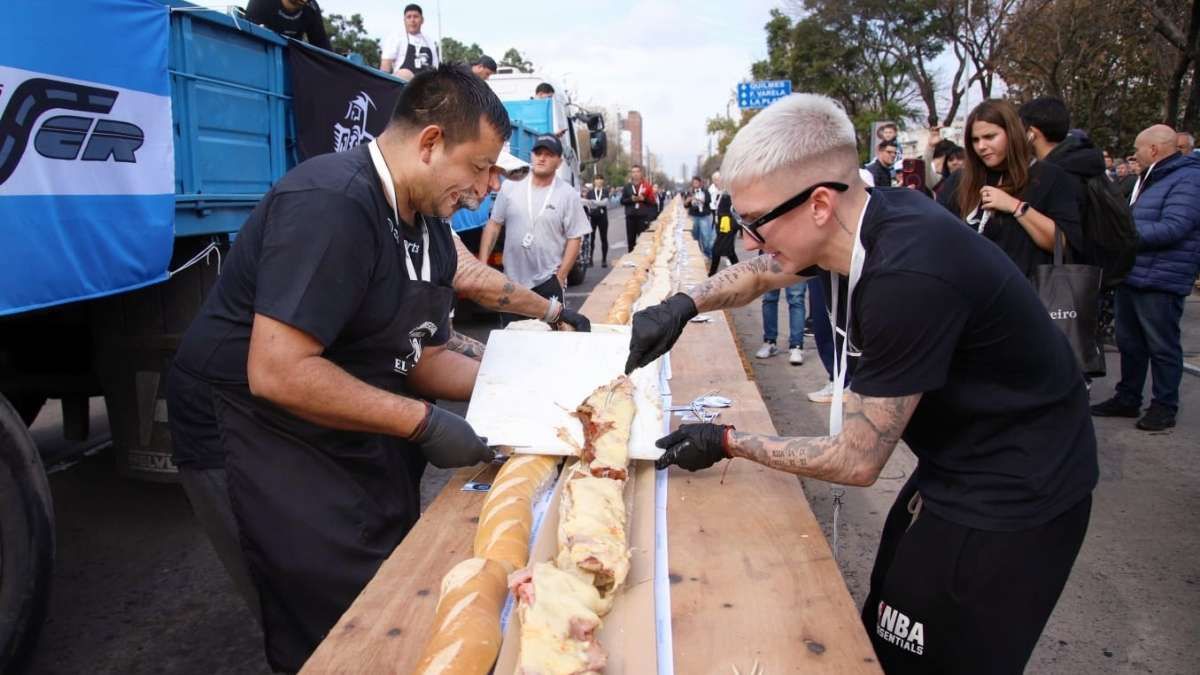 Cientos de personas avanzaron sobre las mesas y se llevaron porciones del gigantesco sándwich antes de que comenzara la entrega oficial en Avellaneda.