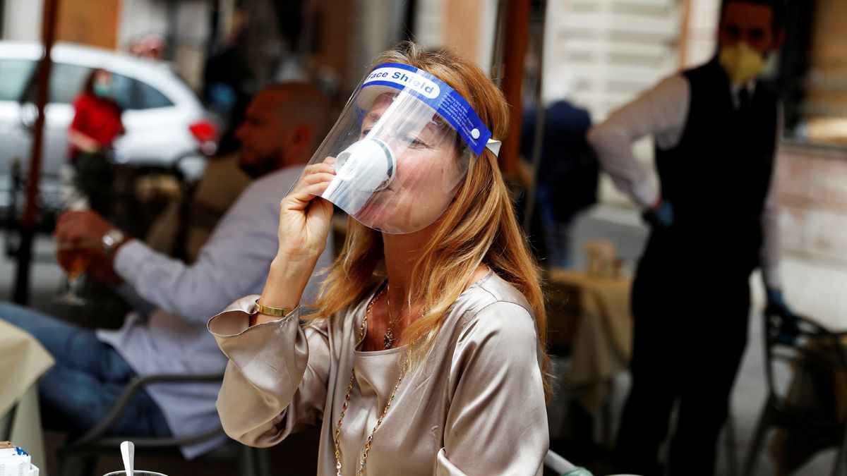 Una mujer con una m&aacute;scara protectora toma un caf&eacute; en un bar de Roma este lunes&nbsp;