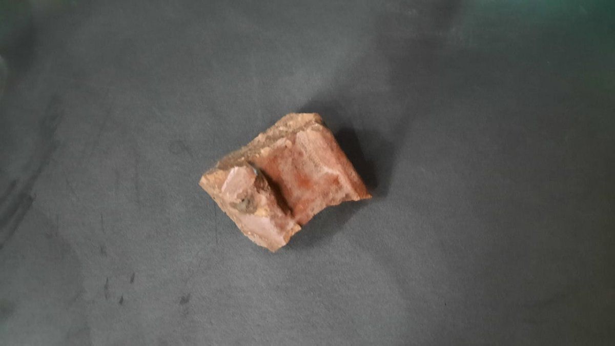 El conductor del colectivo atacado mostró la piedra con la que rompieron el vidrio del coche.