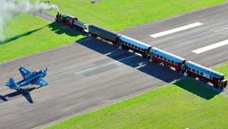 Esta fotografía se tomó en 2013 durante la realización de un festival aéreo, donde un torpedero Grumman TBF Avenger de la Segunda Guerra Mundial espera en la pista el paso de una formación de la empresa Gisborne City Vintage Railway, encabezado por la locomotora Wa165 de 1897.
