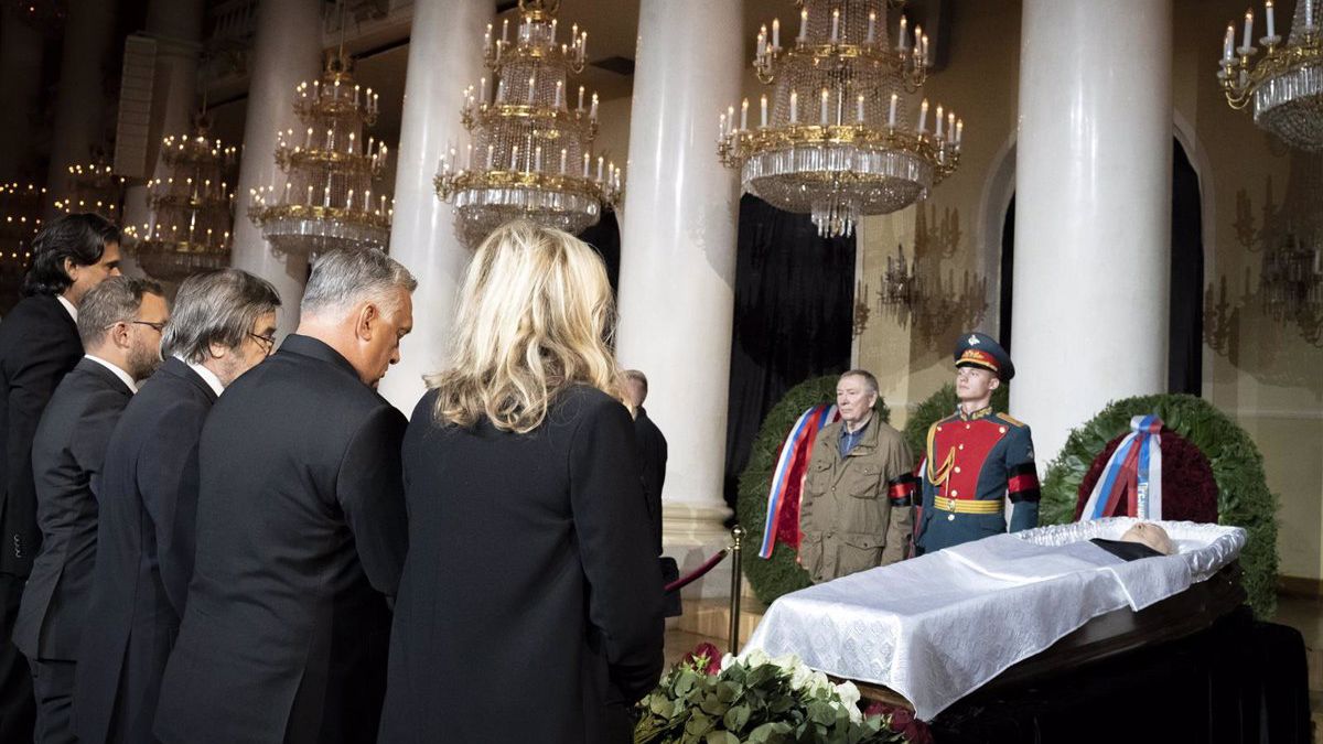 Flanqueando el féretro se encontraban dos guardias de uniforme, mientras los visitantes depositaban flores y se inclinaban en señal de respeto.