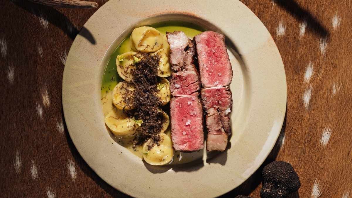 Bife de novillo madurado dry-aged con capelettis de ricota casera, kale de la huerta y trufa negra. Bife de novillo madurado dry-aged con capelettis de ricota casera, kale de la huerta y trufa negra.