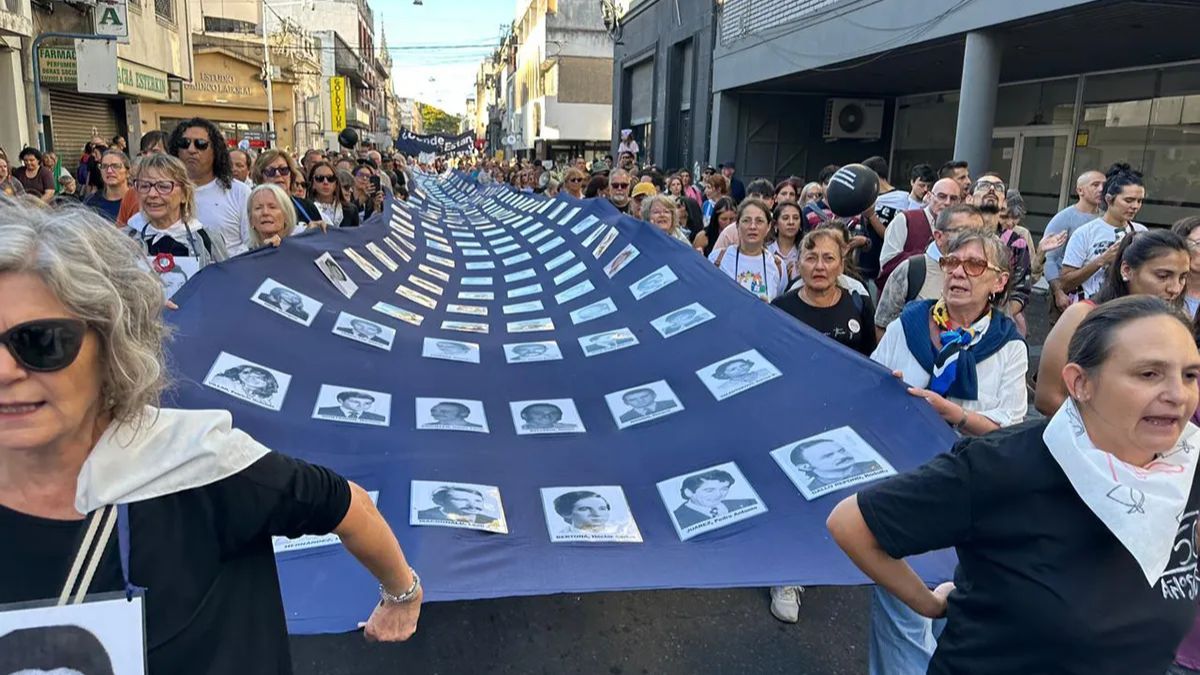 Manifestantes sostuvieron, una vez m&aacute;s, la extensa tela azul con las fotograf&iacute;as de las y los desaparecidos santafesinos.