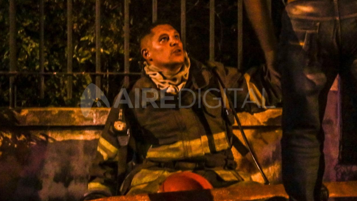 Un bombero se muestra exhausto luego de sofocar el incendio de una vivienda en Santo Tomé este miércoles. 