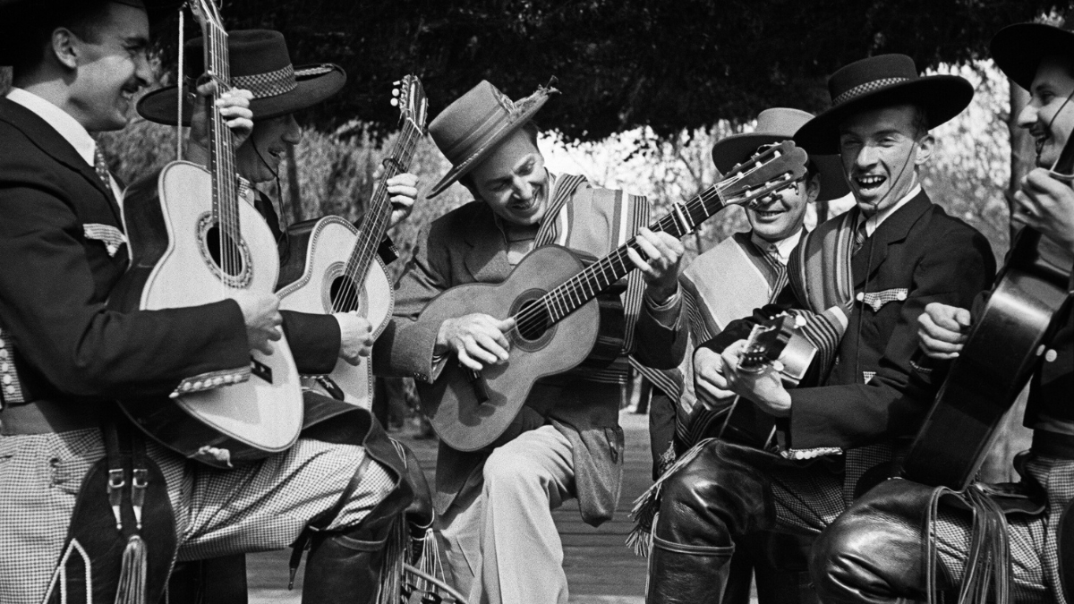 Walt se esfuerza por tocar la guitarra para los miembros de Los Quincheros, Santiago, Chile. ©Disney Archives. Gentileza ArtexArte