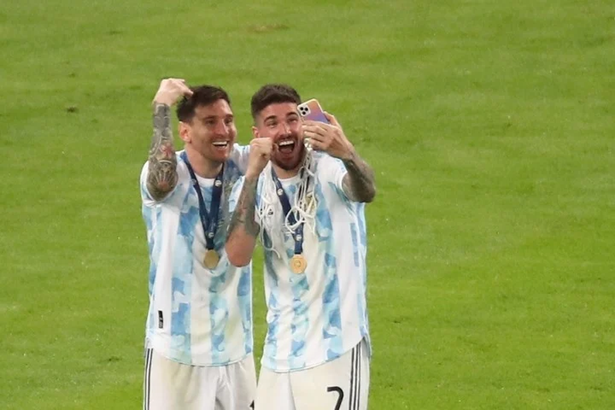 Lionel Messi y Rodrigo de Paul hablan por celular tras celebrar el triunfo ante Brasil, en la final de la Copa América. Foto EFE  