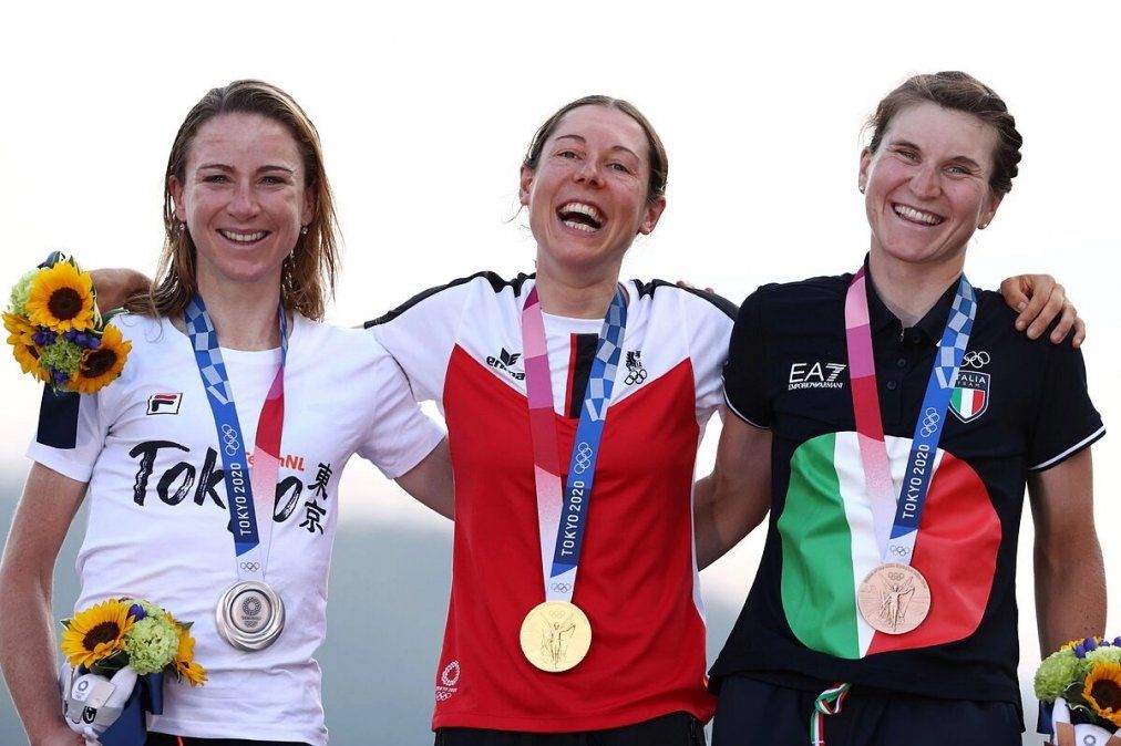 Anna Keisenhofer, primera en el podio luego de consagrarse en ciclismo de ruta en los Juegos Olímpicos de Tokio. A su derecha, la neerlandesa Annemiek van Vleuten, quien salió segunda y completa la italiana Elisa Borghini, tercera.