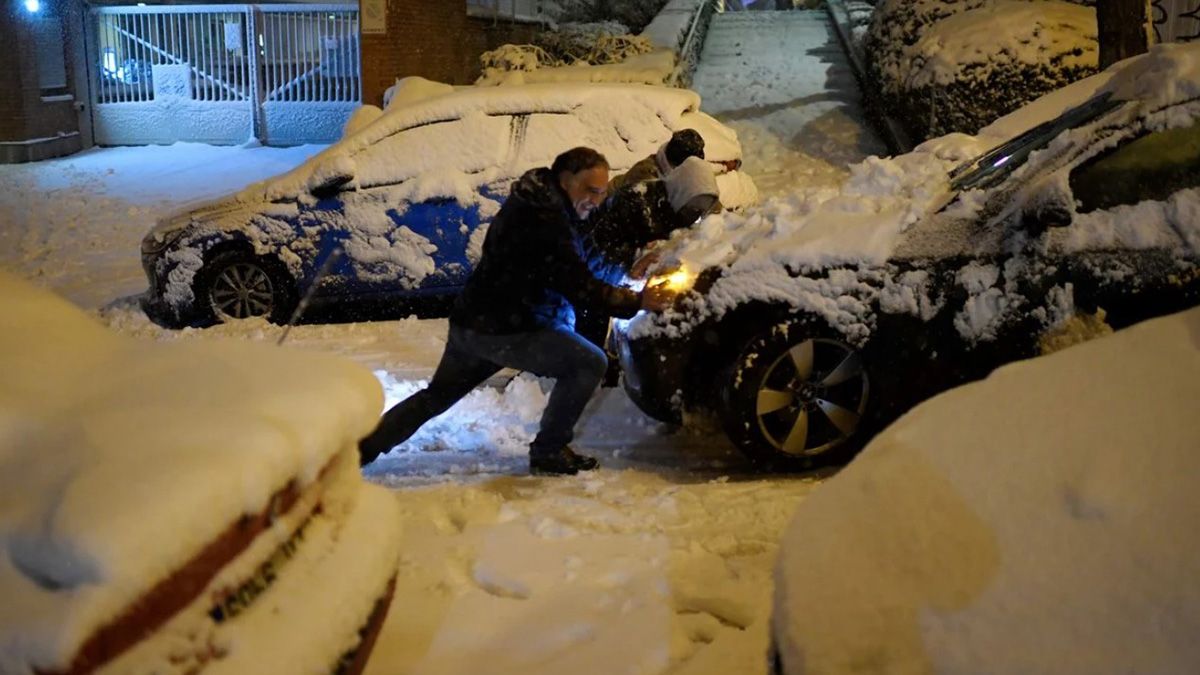 Un hombre intenta mover su auto durante el brutal temporal de nieve en Madrid.