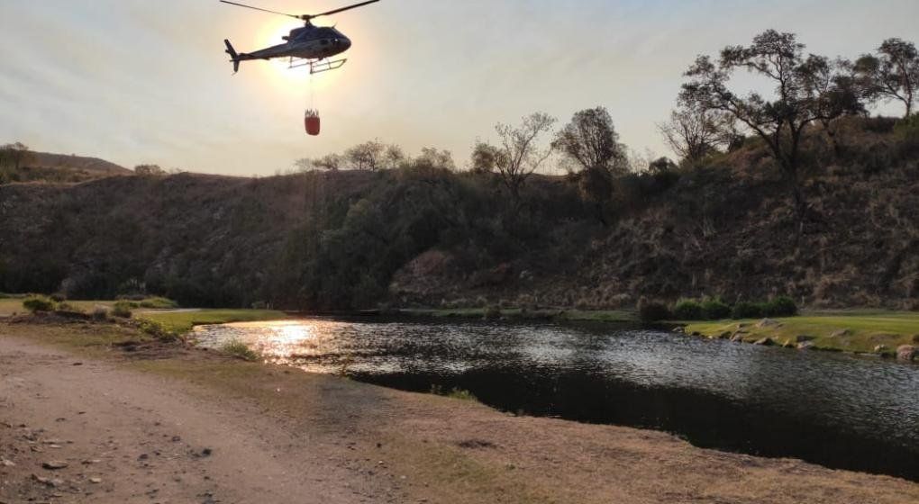 El helicóptero de la Provincia toma agua en Potrerillo para asistir a bomberos en Alta Gracia. (Gentileza Santiago Menéndez)