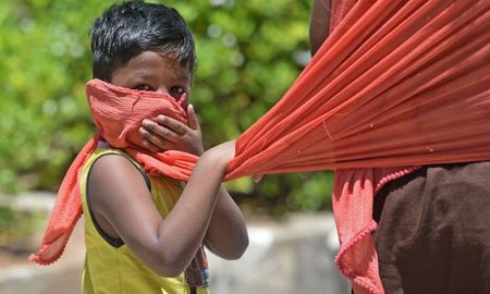 Niño se cubre la cara con el pañuelo de su madre en Chennai, India. Niño se cubre la cara con el pañuelo de su madre en Chennai, India.