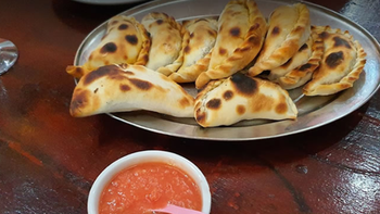 Una persona fue a comer a Doña Salta, pidió 4 empanadas de carne y 2 locros: cuánto gastó