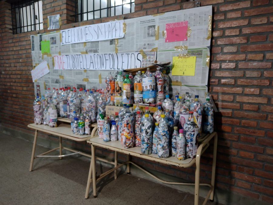 Los alumnos de quinto primera están colocando los folletos dentro de botellas vacías de plástico y de esa forma realizan ladrillos reutilizables.