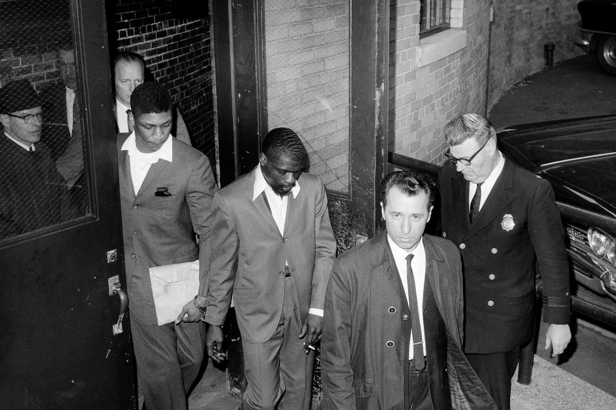 El 29 de junio de 1967, el juez Samuel Larner le impuso una cadena perpetua simultánea y dos consecutivas a Rubin Carter, y tres cadenas perpetuas simultáneas a John Artis. En la foto, Carter (centro), esposado con Artis (detrás y a su derecha), abandonan el Palacio de Justicia del Condado de Passaic en Paterson, Nueva Jersey, tras ser condenados.