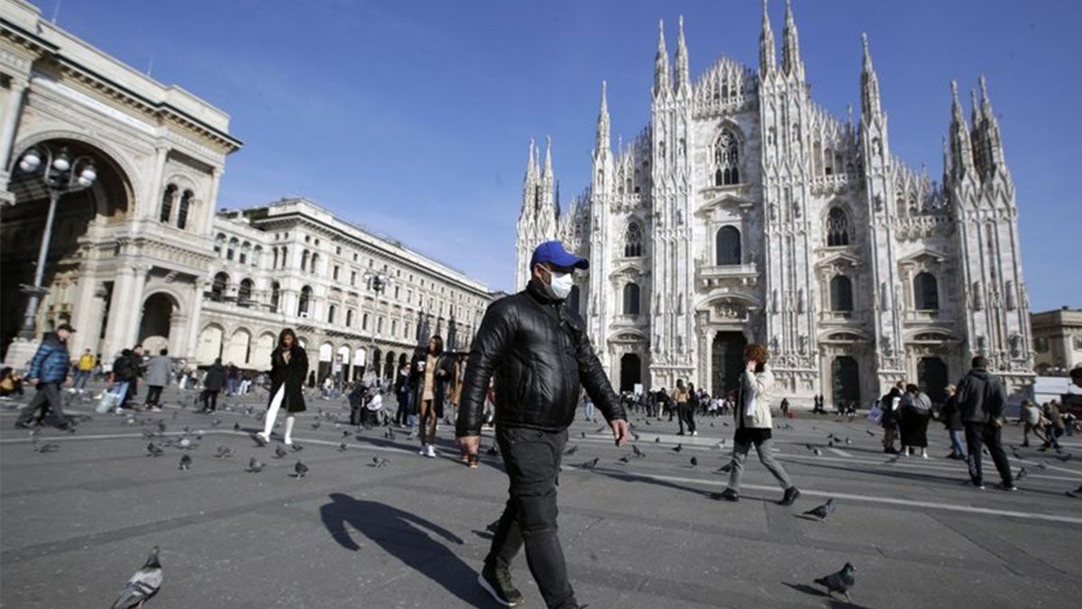 En esta fotografía de archivo del 24 de febrero de 2020 se ve a un hombre con mascarilla que camina frente a la catedral en Milán