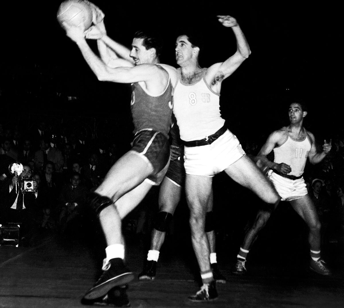 Oscar Alberto Furlong disputa una pelota ante la mirada de Ricardo Primitivo González (11). Para conquistar el título en el primer Mundial de la FIBA de la historia, la Selección ganó los seis partidos que disputó: venció a Francia (dos veces, una en la ronda inicial y, la otra, en la fase final), Brasil, Chile, Egipto y, en el choque decisivo, a los Estados Unidos, considerado el mejor equipo de la época.