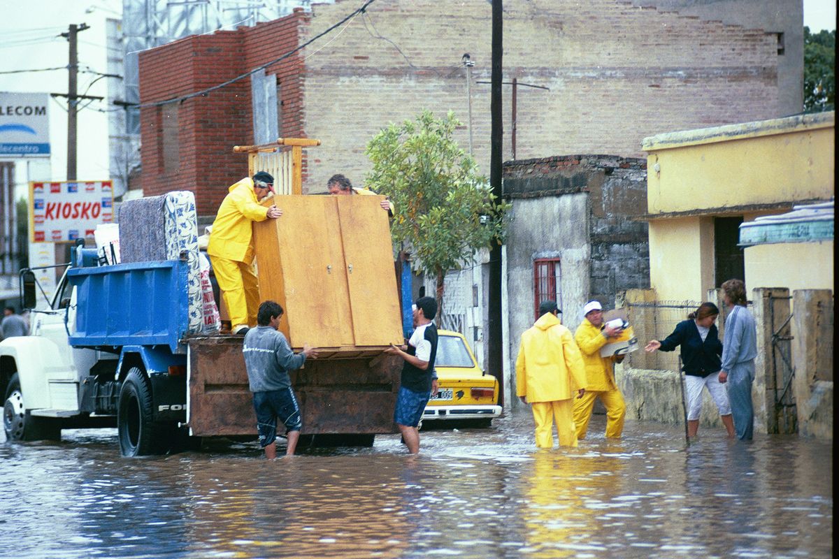 El agua no daba tregua. Con los pies en el agua, los vecinos trataban de salvar lo que podían de sus casas.