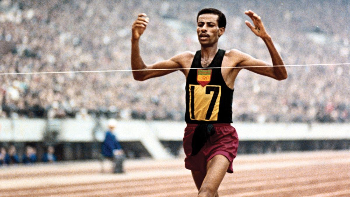 El miércoles 21 de octubre de 1964, Bikila se alzó con el oro en el maratón de los Juegos Olímpicos de Tokio, y con un nuevo récord mundial. Esta vez, corrió con zapatillas alemanas Puma hechas a medida, y ganó a pesar de que solo 35 días antes le habían practicado una apendicectomía. El miércoles 21 de octubre de 1964, Bikila se alzó con el oro en el maratón de los Juegos Olímpicos de Tokio, y con un nuevo récord mundial. Esta vez, corrió con zapatillas alemanas Puma hechas a medida, y ganó a pesar de que solo 35 días antes le habían practicado una apendicectomía.