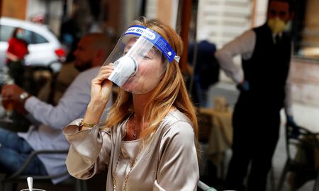 Una mujer con una máscara protectora toma un café en un bar de Roma este lunes Una mujer con una máscara protectora toma un café en un bar de Roma este lunes