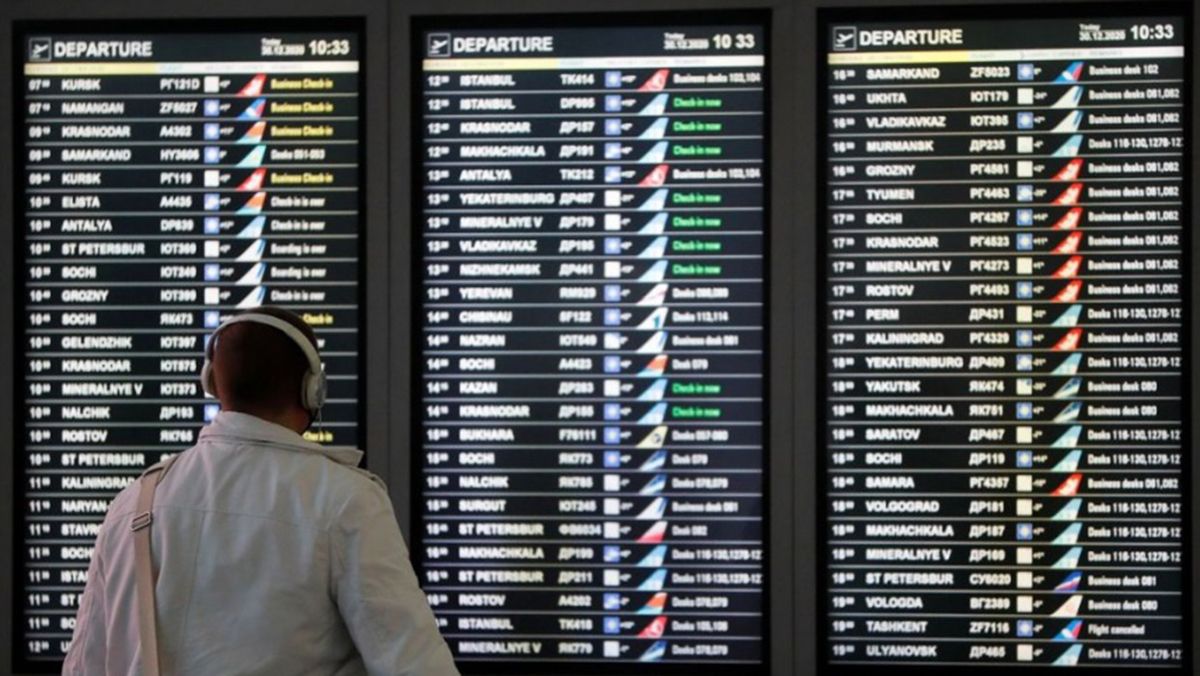 Un hombre mira un tablero de información de vuelos en la zona de salida del Aeropuerto Internacional Vnukovo en Moscú.