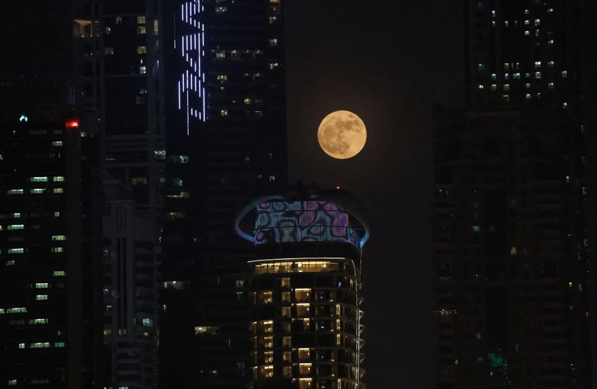 La súper luna llena de ciervo se eleva detrás del puerto deportivo de Dubái en el emirato del Golfo de Dubái, el 13 de julio de 2022.