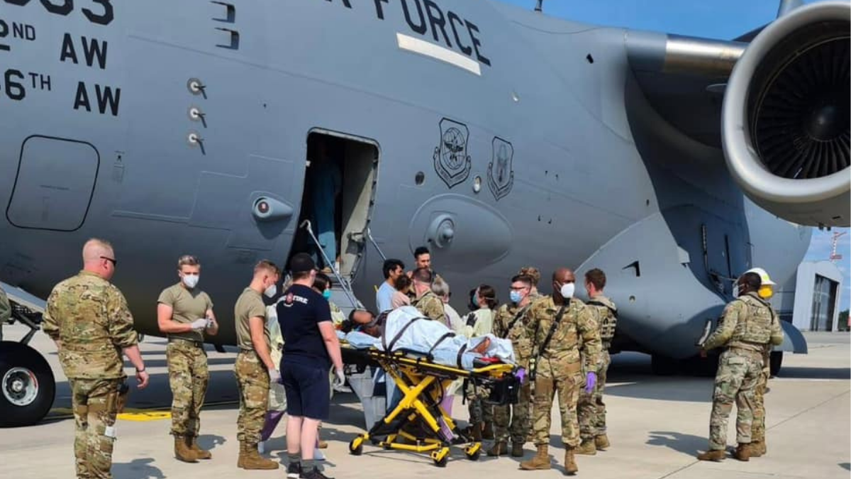 La mujer que huía de Afganistán fue trasladada en camilla hacia un centro asistencial luego del parto.