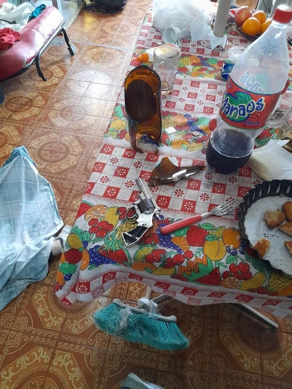 Así encontró la Policía la escena del crimen: el revólver y una botella de cerveza rota.