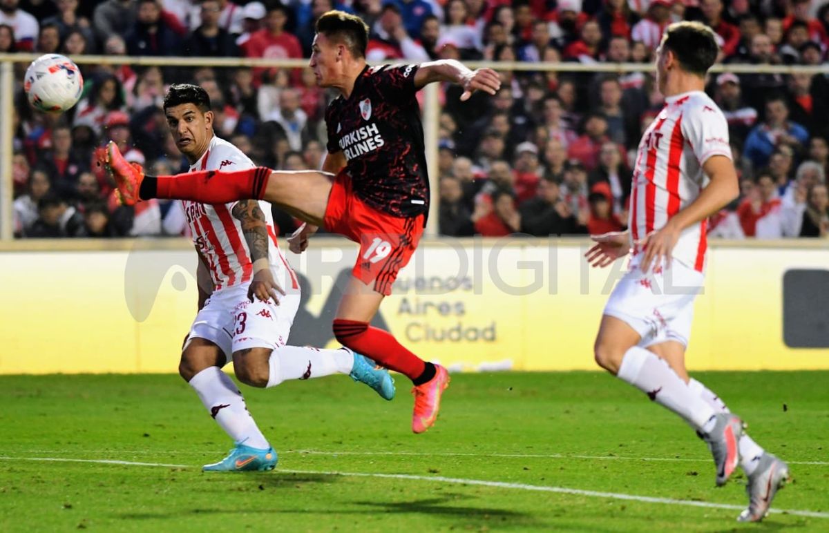Diego Polenta corre para evitar que Braian Romero controle la pelota durante el partido entre Unión y River.