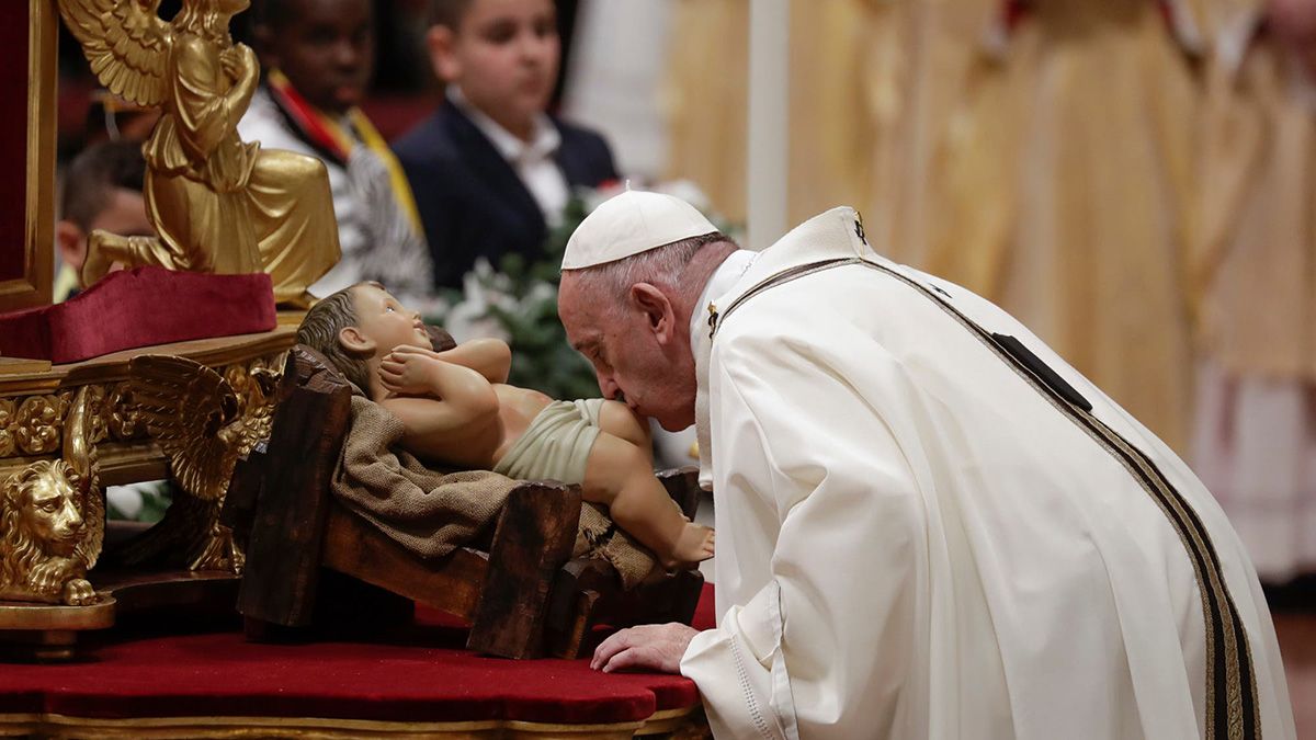 Francisco besa los pies de una imagen del Niño Jesús en la noche de Navidad, en la Misa de Gallo.