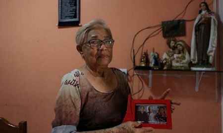 Maria Moitinho Nunes Sinimbu, quien perdió a cinco familiares por la COVID-19, entre ellos tres hijos de quienes muestra una foto. | Fuente: AFP | Fotógrafo: Michael Dantas Maria Moitinho Nunes Sinimbu, quien perdió a cinco familiares por la COVID-19, entre ellos tres hijos de quienes muestra una foto. | Fuente: AFP | Fotógrafo: Michael Dantas