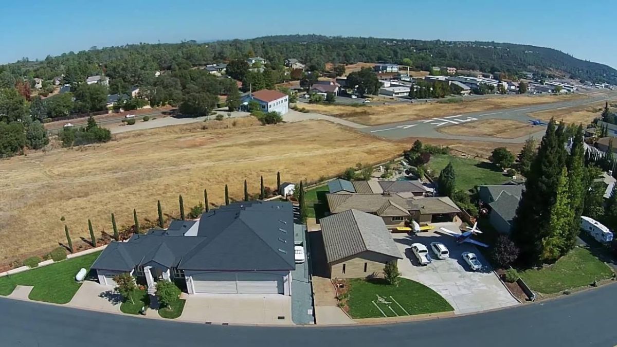 La cabecera 13 vista desde el oeste, donde se destacan las residencias con garages y hangares para el estacionamiento de autos y aviones. En la actualidad, hay unas 110 aeronaves en Cameron Airpark: un 88% son monomotores y, el 12%, multimotores.