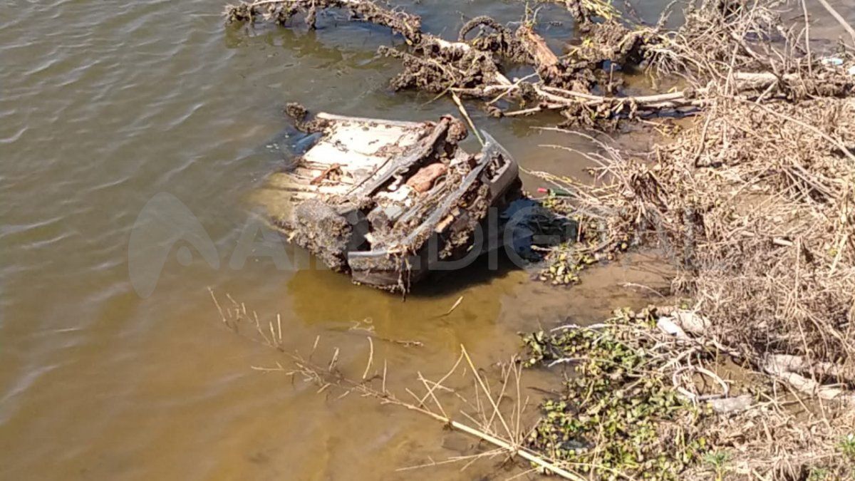 El auto está apoyado sobre el lecho del río Coronda con los neumáticos hacia arriba.