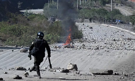 Un agente antidisturbios retira piedras de una carretera bloqueada por manifestantes rurales en Lipari, departamento de La Paz, Bolivia, el 16 de mayo de 2026. Un agente antidisturbios retira piedras de una carretera bloqueada por manifestantes rurales en Lipari, departamento de La Paz, Bolivia, el 16 de mayo de 2026.