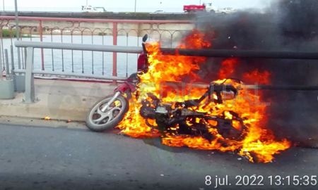 La moto se consumió en llamas sobre la calzada, cerca de la baranda de hierro del puente La moto se consumió en llamas sobre la calzada, cerca de la baranda de hierro del puente
