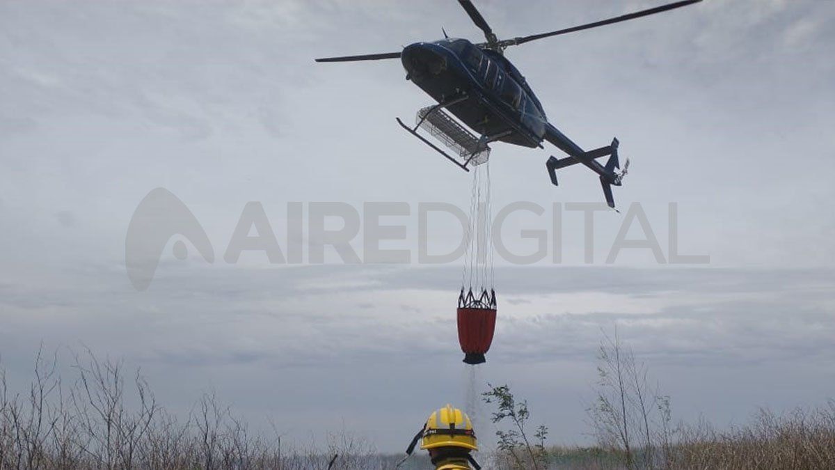 Ante la imposibilidad de utilizar aviones hidrantes, la provincia emplea un helibalde para sofocar los incendios.