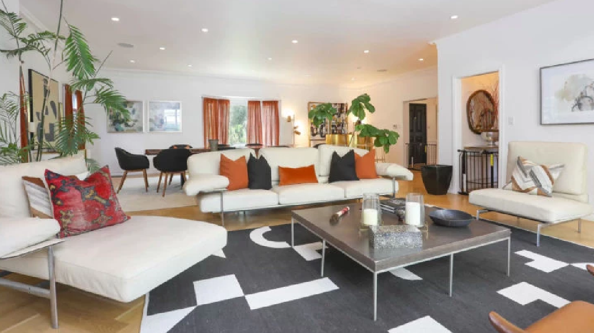 El living cuenta con tres c&oacute;modos sillones tapizados en cuero blanco, una alfombra de dise&ntilde;o, obras de arte distribuidas en todas las paredes.&nbsp;