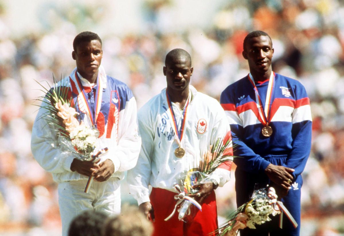 El podio de los 100 metros en los Juegos Olímpicos de Seúl 1988, con Johnson en el centro; Carl Lewis (plata, a su derecha), y el jamaiquino-británico Linford Christie (bronce, a su izquierda). Tras el positivo, el canadiense fue descalificado y, la victoria, quedó en poder del estadounidense, con nuevo récord mundial de 9”92/100 incluido. El podio de los 100 metros en los Juegos Olímpicos de Seúl 1988, con Johnson en el centro; Carl Lewis (plata, a su derecha), y el jamaiquino-británico Linford Christie (bronce, a su izquierda). Tras el positivo, el canadiense fue descalificado y, la victoria, quedó en poder del estadounidense, con nuevo récord mundial de 9”92/100 incluido.