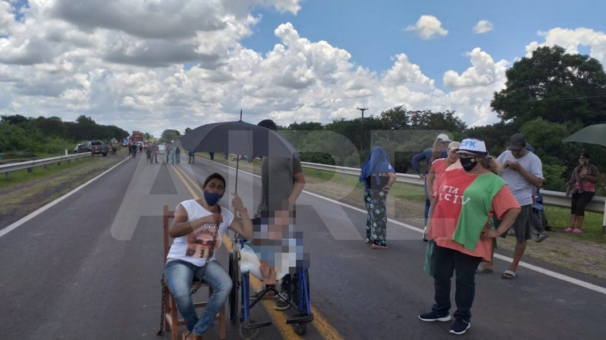 Mirta Vallejos, de remera roja, barbijo y gorra blanca, liderando el corte. En la foto se observa también a la mujer que reclamaba la asistencia alimentaria.