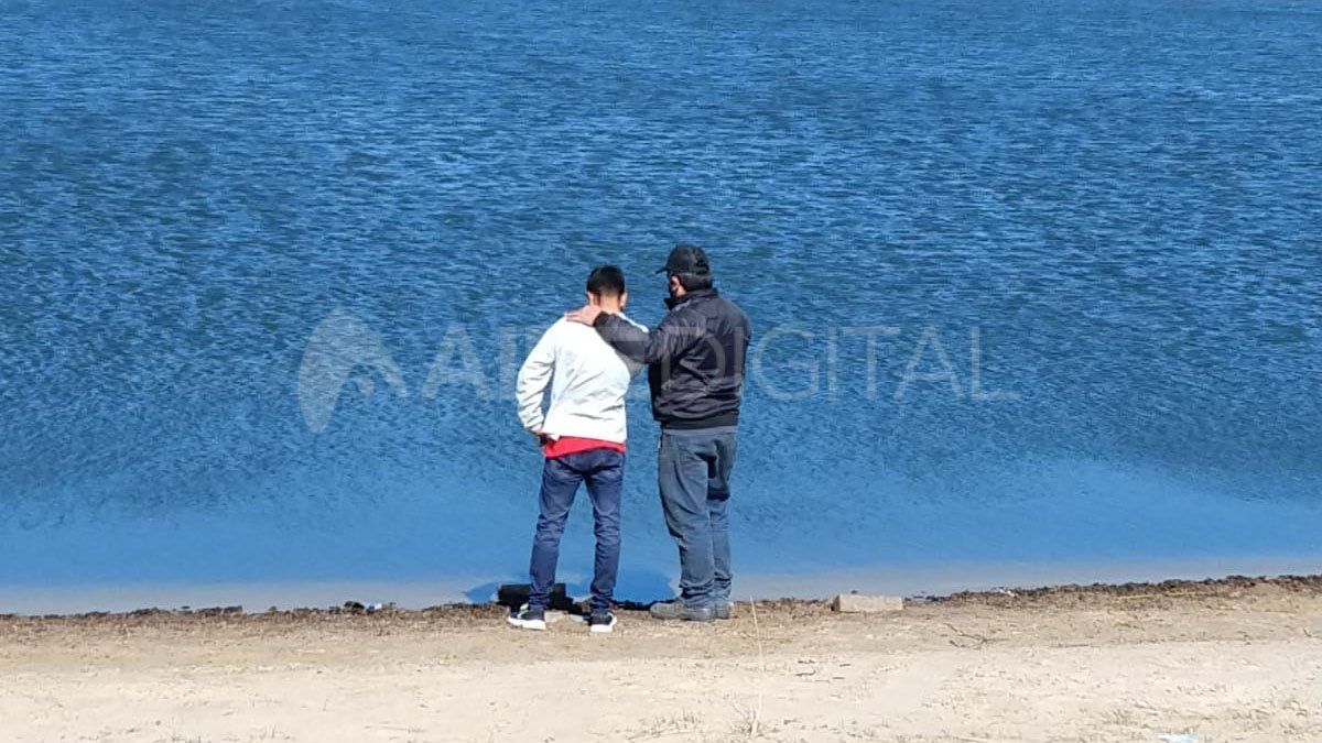 La policía consuela a uno de los familiares de las personas ahogadas en este laguna de Colastiné Norte.