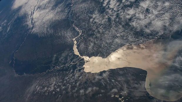 En esta foto tomada desde la Estación Espacial Internacional, el Río de la Plata separa a Argentina y Uruguay. Apenas visible, se encuentra la populosa ciudad de Buenos Aires, Argentina, en la desembocadura del delta del Paraná, que desemboca en el Río de la Plata.
