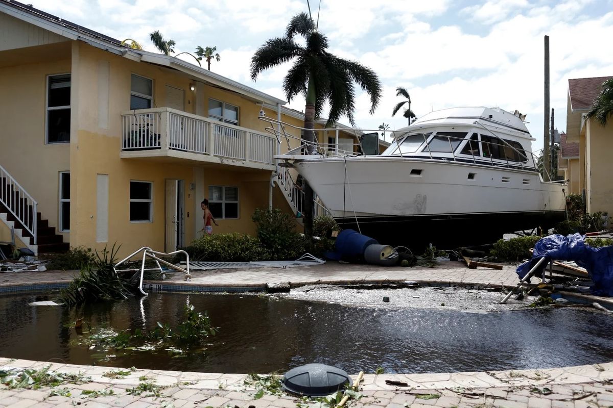 Un barco al lado de una casa, tras el paso del huracán Ian.