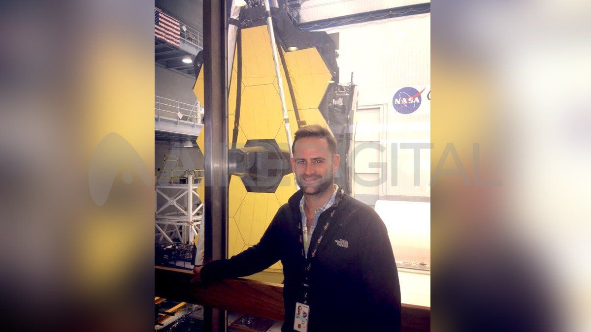 NASAs planetforsker Lucas Paganini står ved siden av James Webb-teleskopet ved NASAs Goddard Space Flight Center.