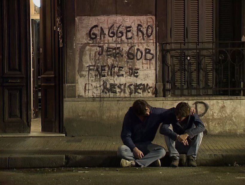 "El Chiqui" consolando a "Ricardo" en la entrada de la casa ocupada en la ciudad de Buenos Aires.