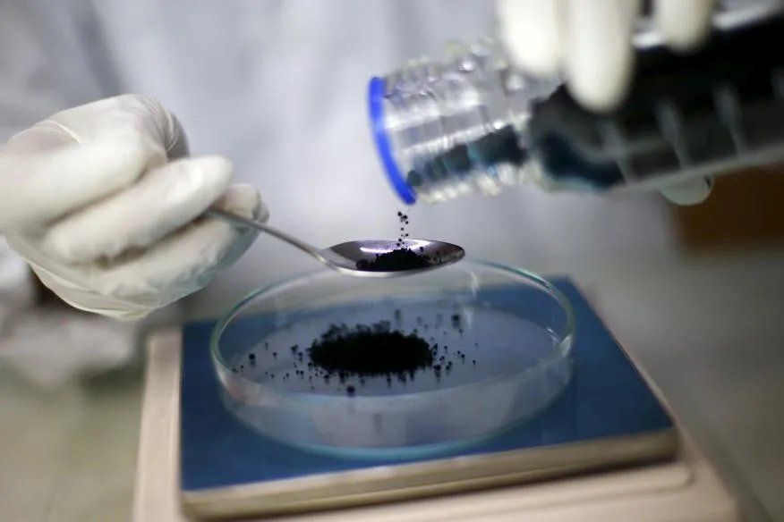 Un trabajador pesando grafeno en una báscula.